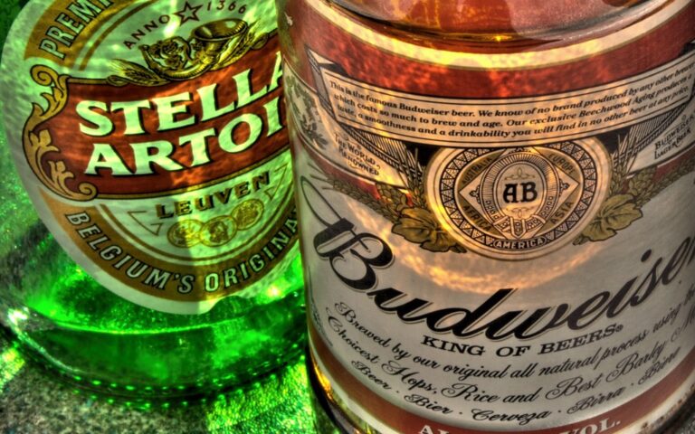 Close-up of Stella Artois and Budweiser beer bottles, highlighting their labels.