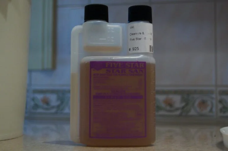 Three bottles of Five Star cleaning and sanitizing products on a kitchen countertop, with a focus on the front purple-labeled bottle.
