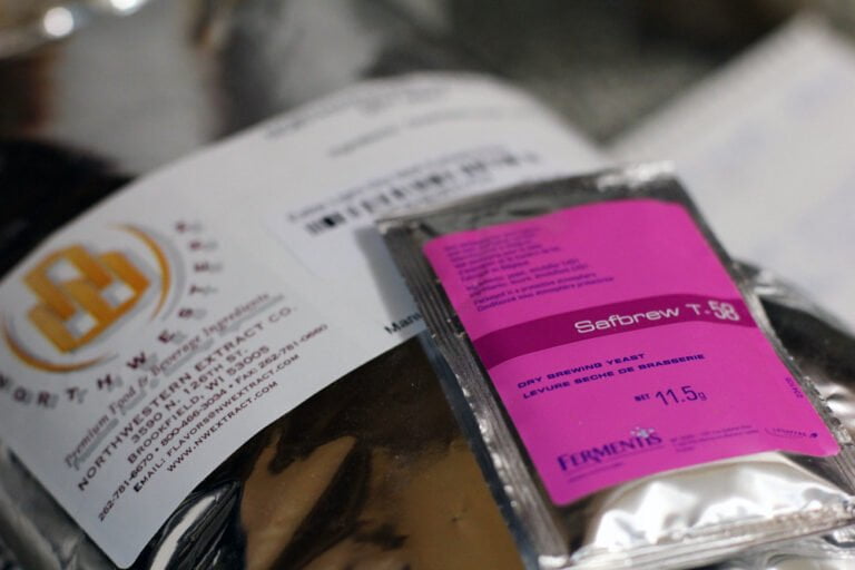 Close-up of a Safbrew T-58 dry brewing yeast packet, with a partially visible company label in the background.