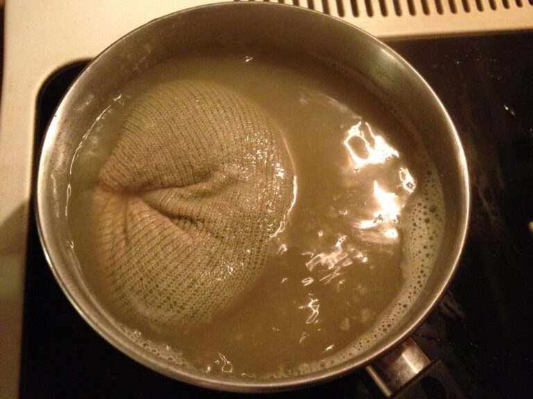 A large pot on a stove containing water and a turkey inside a boiling bag, with bubbles indicating the water is heated.