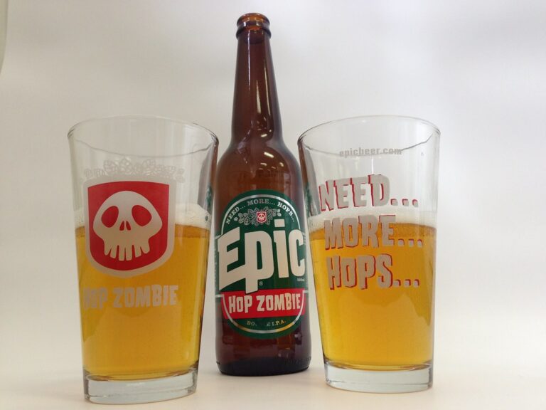 Two pint glasses of beer with different logos ("HOP ZOMBIE" on the left, "NEED... MORE... HOPS..." on the right) flanking a central beer bottle labeled "Epic HOP ZOMBIE" against a white background.