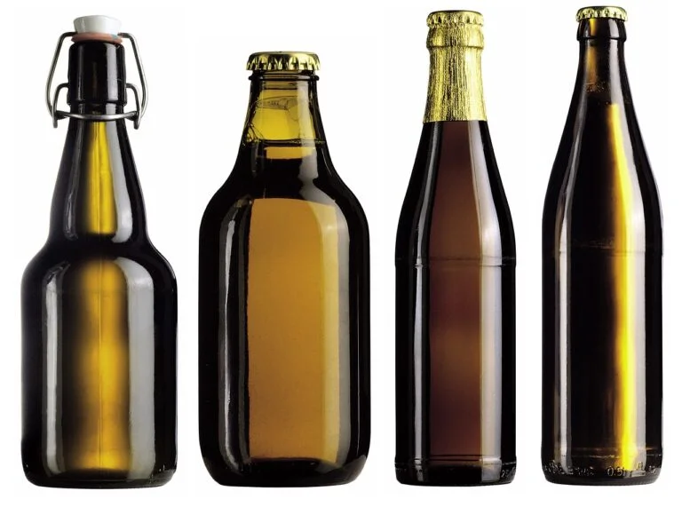 Four different styles of beer bottles against a white background, from left to right: a swing-top bottle, a capped brown bottle with yellow liquid, a brown bottle with gold foil on top, and a larger capped brown bottle with no visible liquid level.