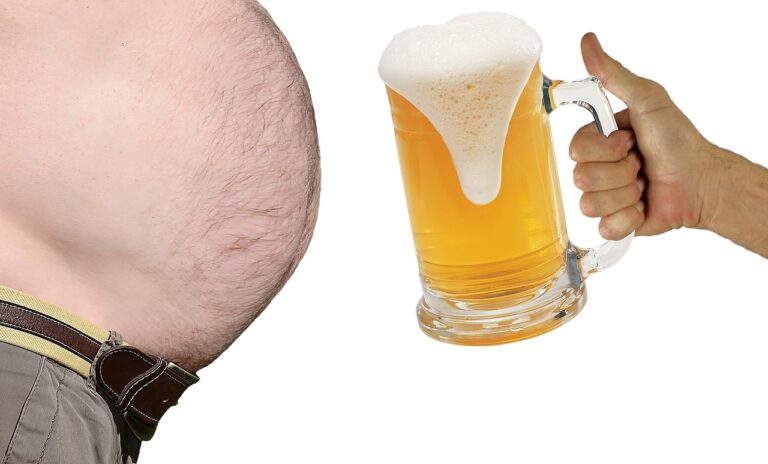 A close-up image split between a man's protruding belly on the left and a hand holding a large mug of beer with frothy head on the right, against a white background.