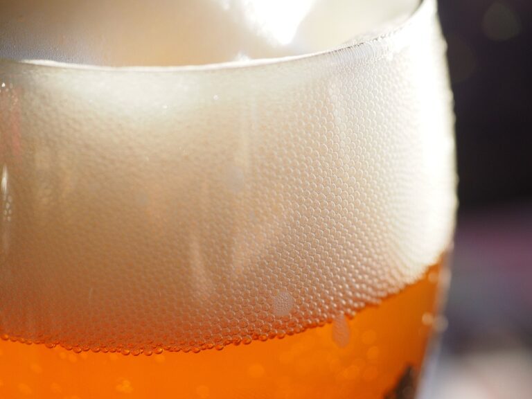 Close-up of condensation beads on the outside of a cold beer glass.