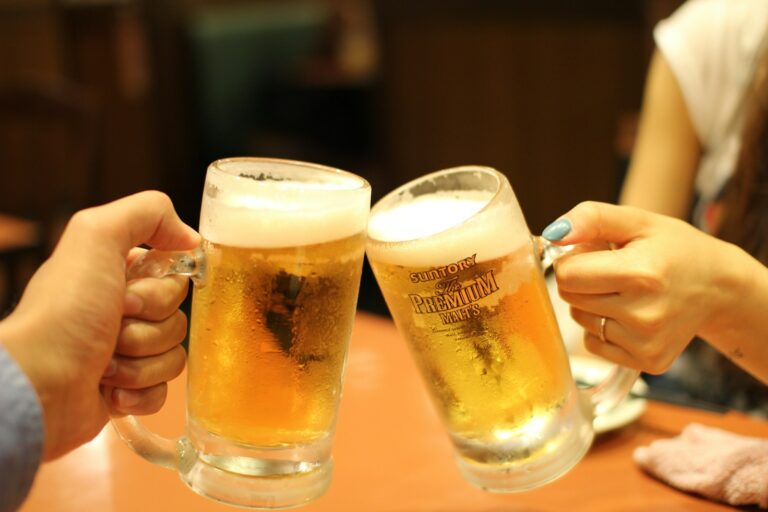 Two individuals clinking frosty glasses of beer, with one glass displaying the "Suntory The PREMIUM MALT'S" logo.